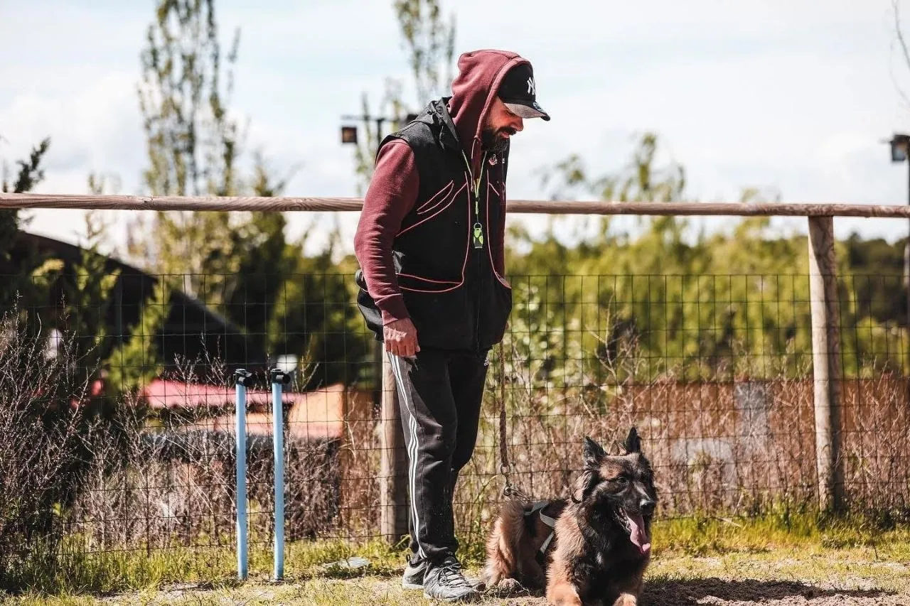 Mikel trabajando con un pastor alemán en el campo